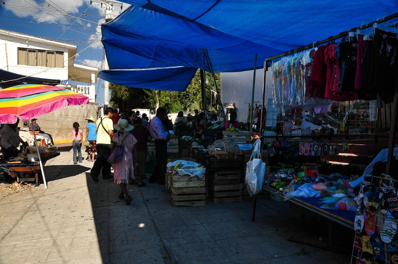 an outdoor market with a lot of items under the tent