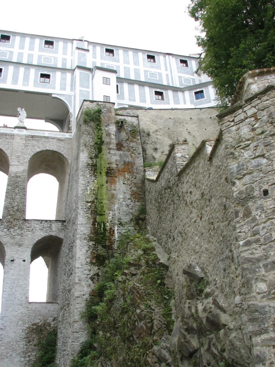 a stone wall near an old building with many windows