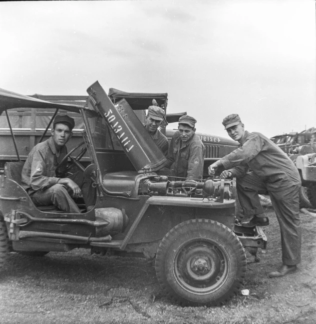 three men loading a large truck with a person sitting on it