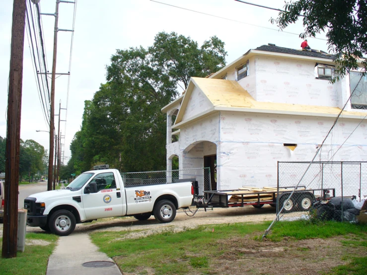 a white truck sitting in front of a house under construction