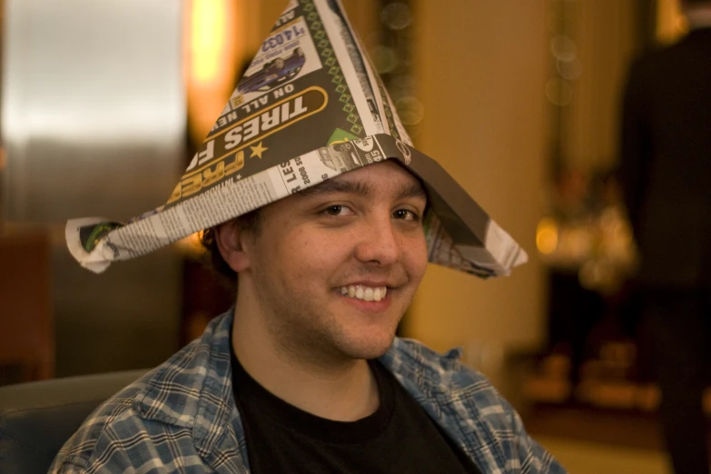 a man in black shirt with paper hat on his head