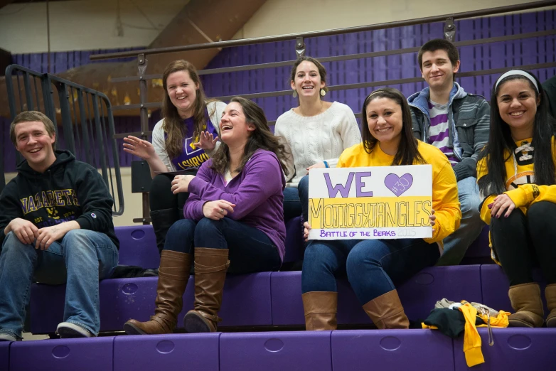 a group of people sitting on top of purple benches