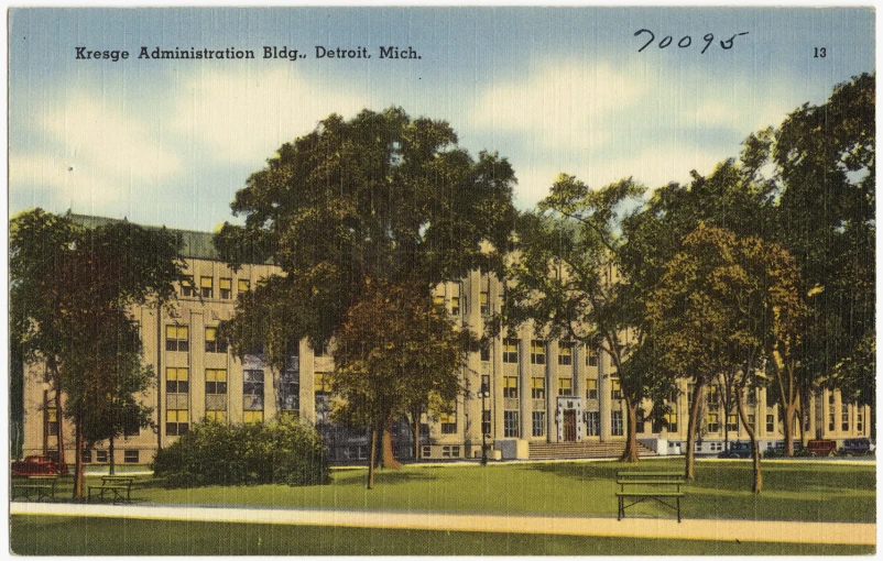 a large building sits behind several trees