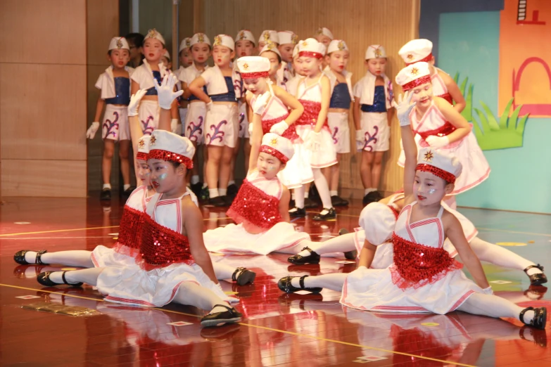 a group of children dressed in costumes sit on the floor