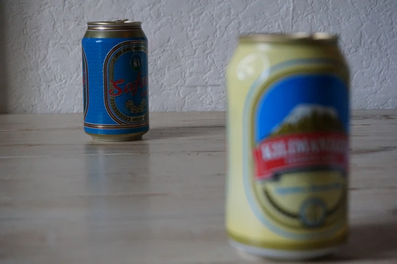 two small cans on a wooden table