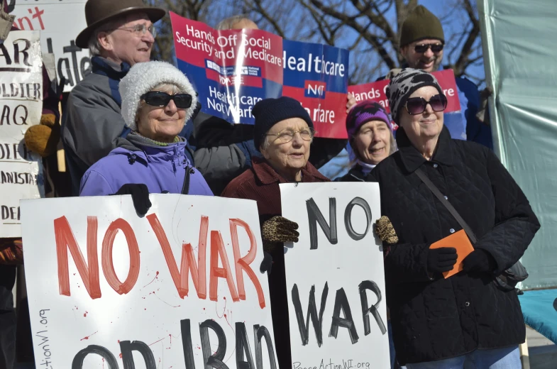 several people holding signs at a protest outside