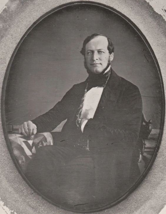 a man wearing a suit and sitting on top of a chair