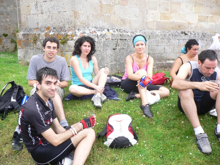 people sitting on the ground with backpacks and a football