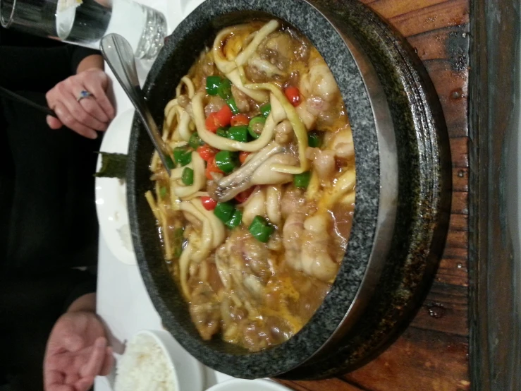 a bowl of food is on a wood table