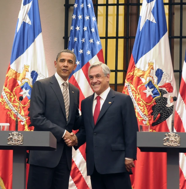 two men in suits and ties shake hands