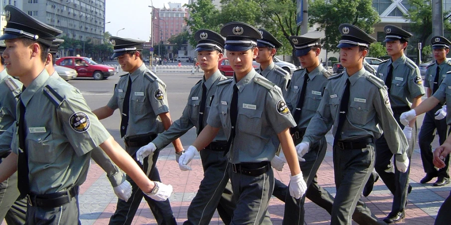 the men are carrying items down the sidewalk