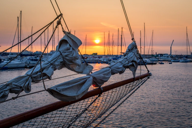 a sunset at a boat dock near the ocean