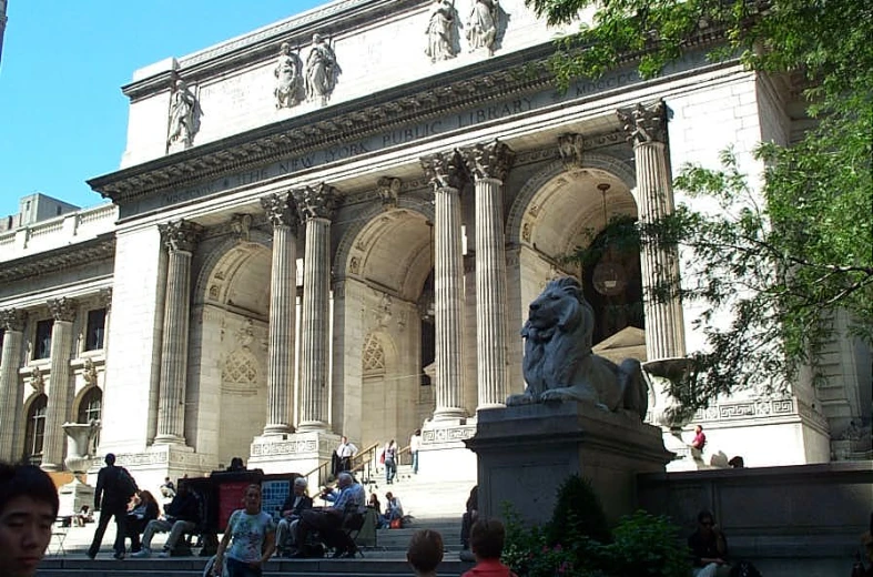 a statue and stairs leading to a large building with arches