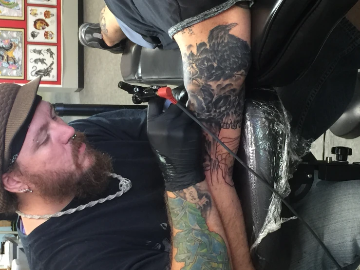 the man with tattooed arms is getting his tattoo done