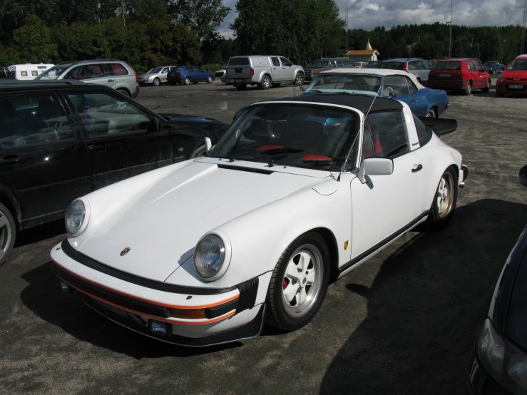 a white porsche 911 parked in a parking lot