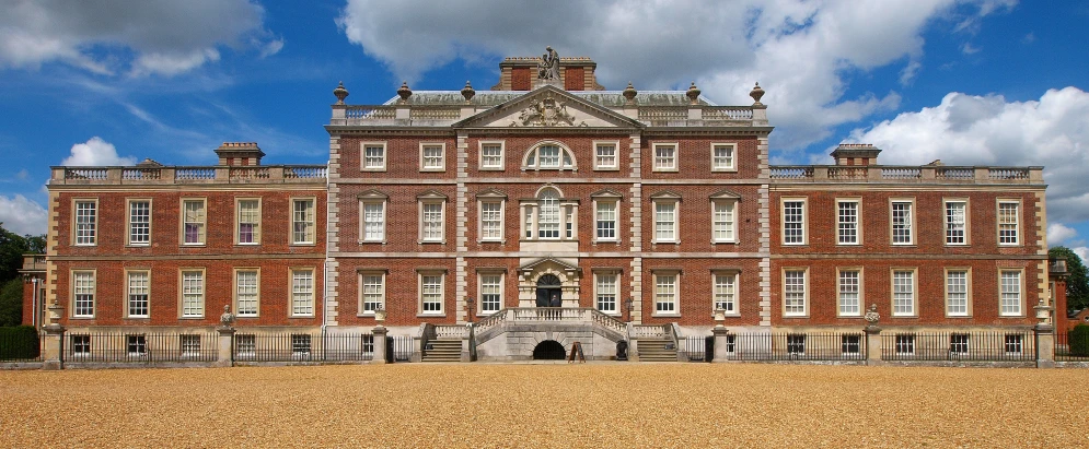 an elaborate red brick building with a balcony on the second floor