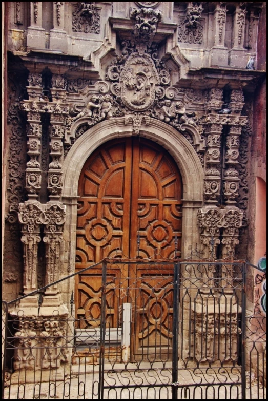 a large, wooden door next to a gate