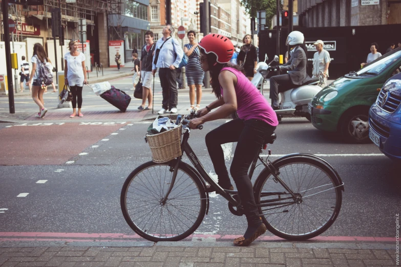 the woman is riding a bike down the street in the city