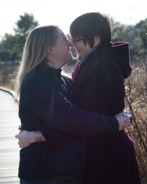 a man and woman kissing while the woman is holding him