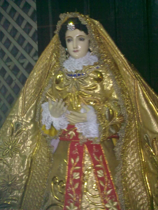 a doll wearing a gold and red outfit