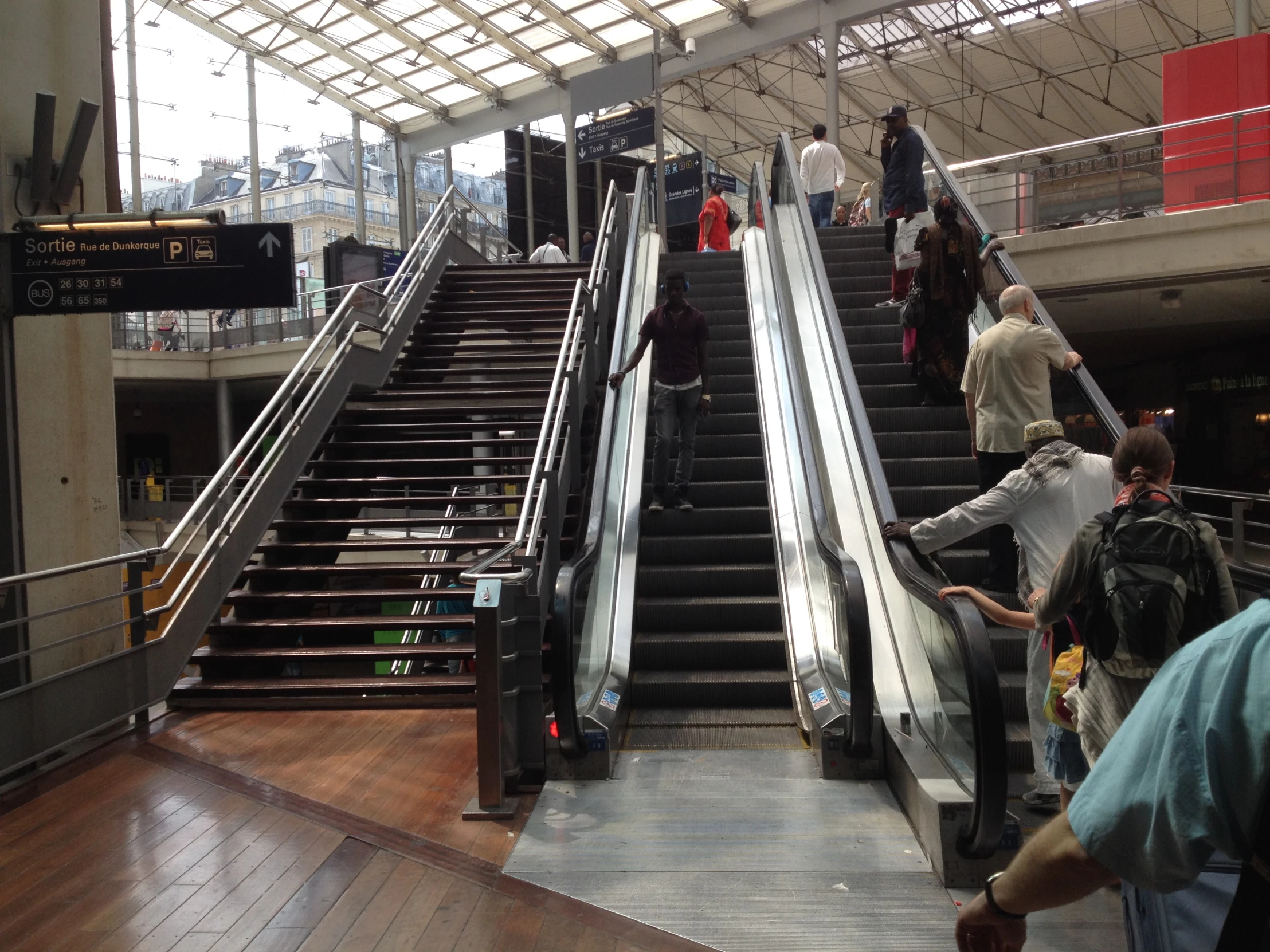 a man riding an escalator with two bags on his shoulder