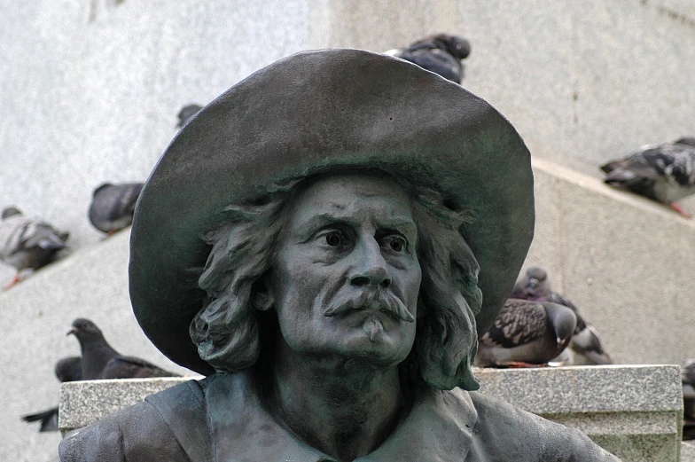 statue with birds near it and on the wall of a building