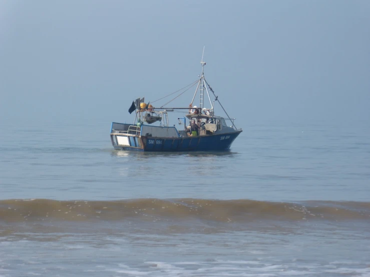 a boat traveling on the ocean in front of some waves