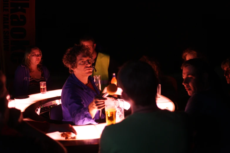 people are sitting around a table at night