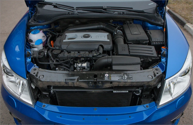 engine compartment view of an older car with a blue metallic finish