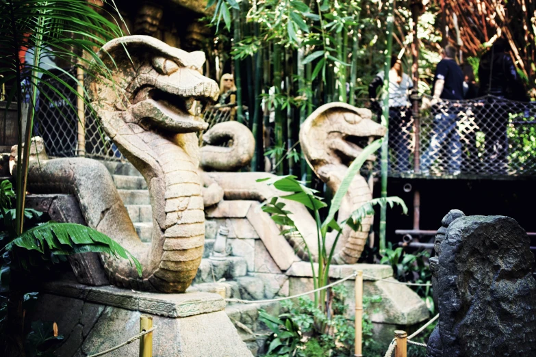 two statues are positioned outside in the jungle