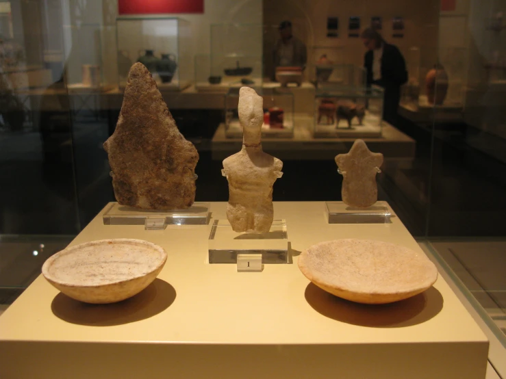 some statues on display inside of a glass case