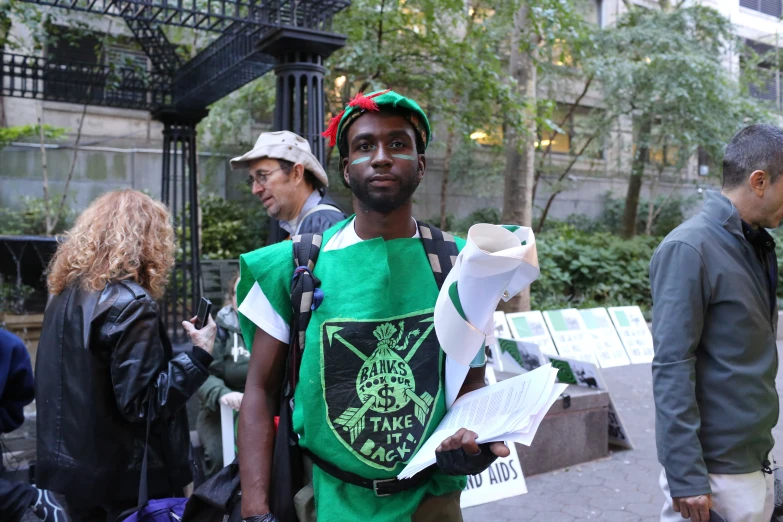 a man in a green shirt is holding some white papers