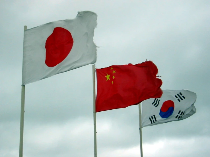 two asian flags blowing in the wind