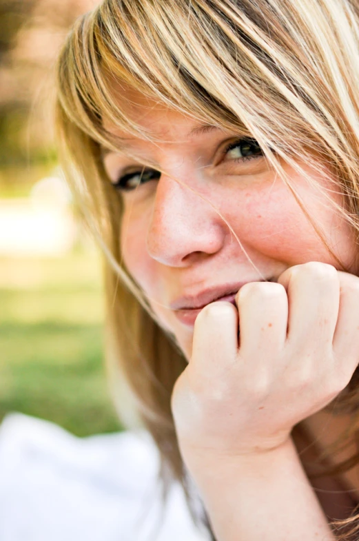 a woman is posing for a po with her hand under her chin