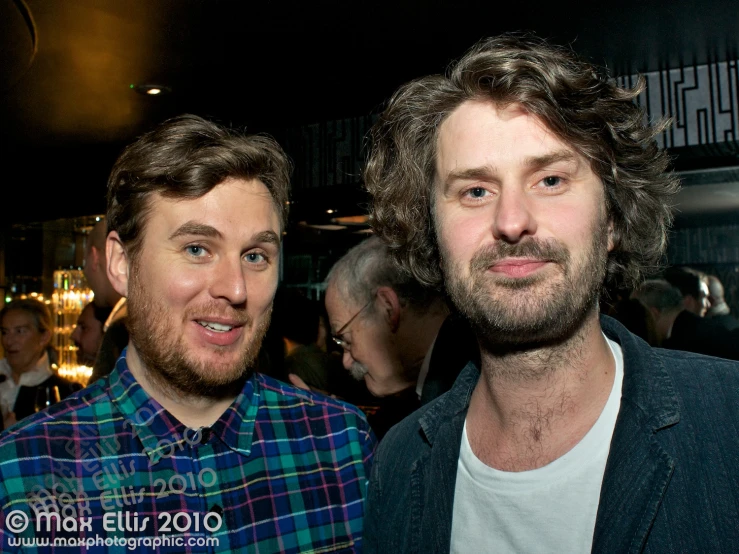 two men standing together in a restaurant