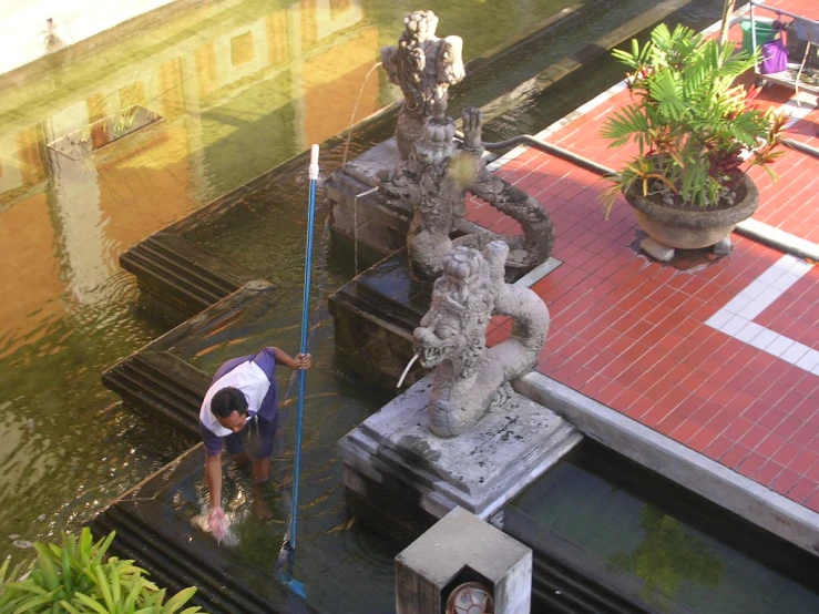 a woman working on the water inside of a pond