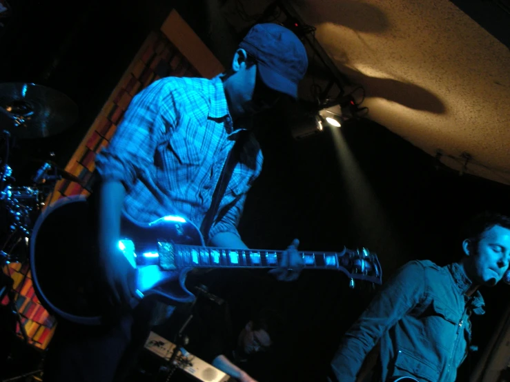 two guys are playing musical instruments at night