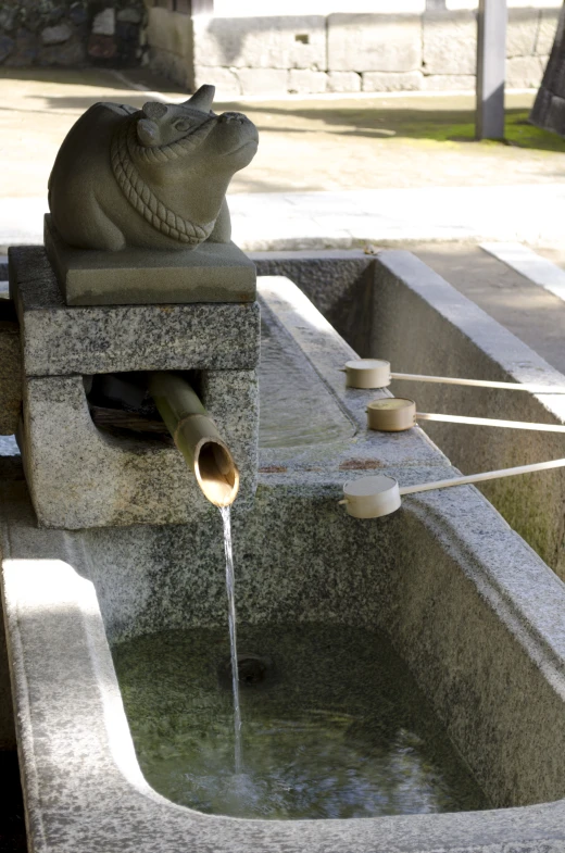 an animal statue is shown in a water feature