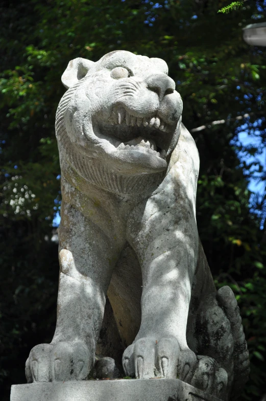 a stone lion statue with a blue sky in the background