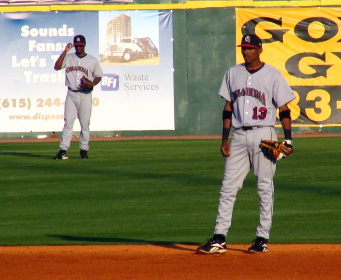 a couple of men standing on top of a baseball field