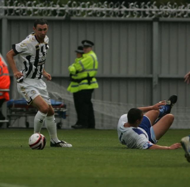 a man is sliding on the ground with a soccer ball
