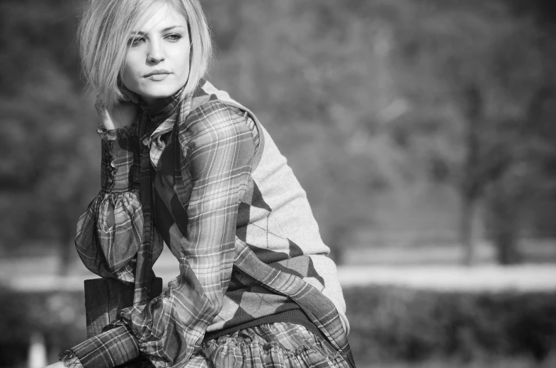 a woman posing in a park with her hand on her hip