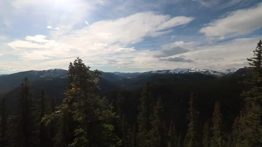 there is a sky view of mountains, trees, and a plane