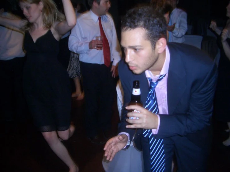 a man is holding up his beer in a group