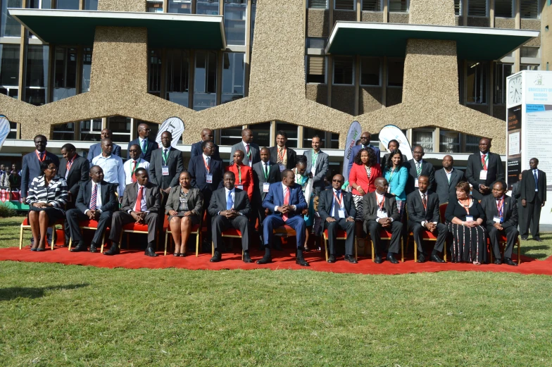 a group of people are sitting on chairs in front of a building