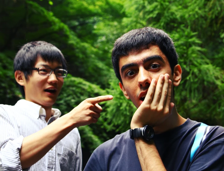 two asian men are making a hand gesture