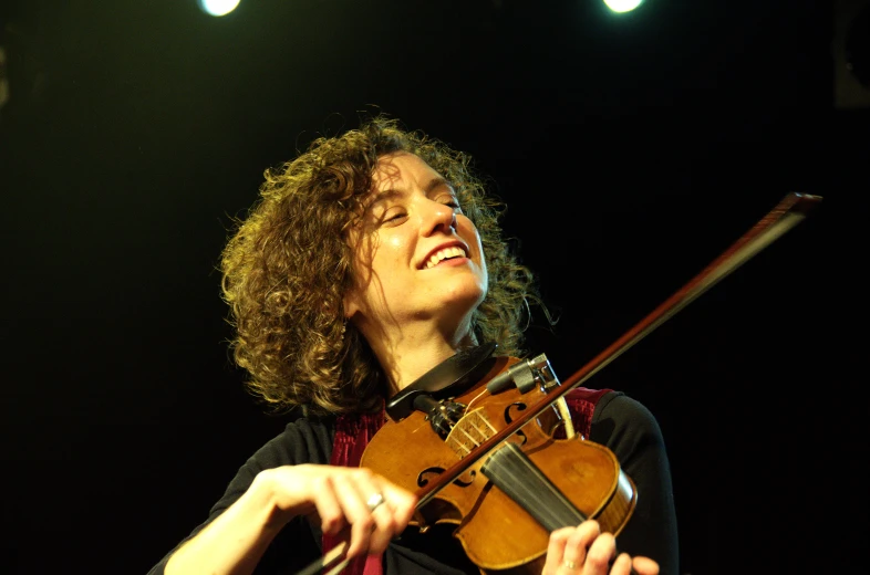 a woman with curly hair holding a violin