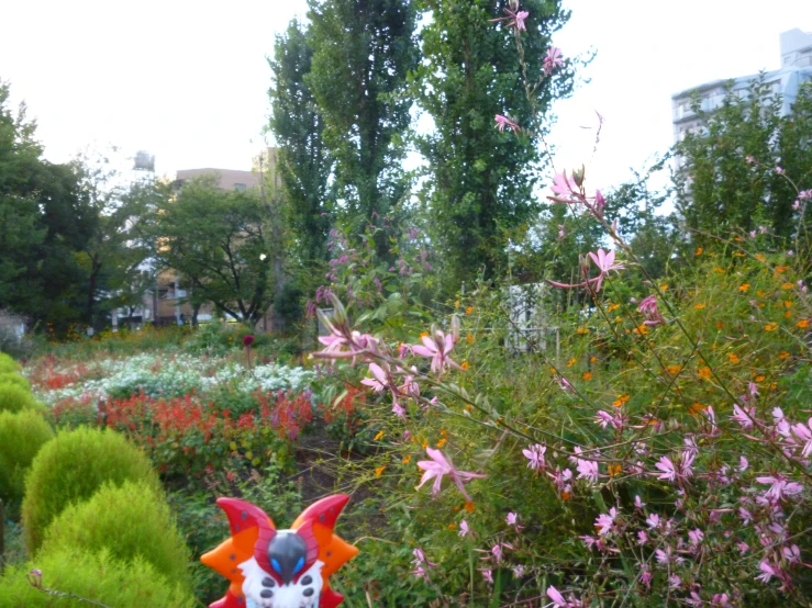 the statue of a demon is next to some flowers