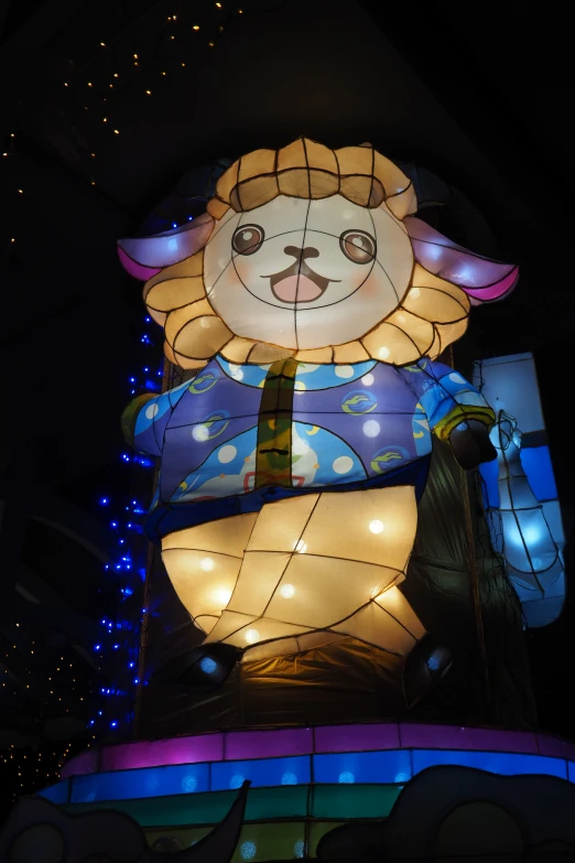 a illuminated teddy bear on a building at night