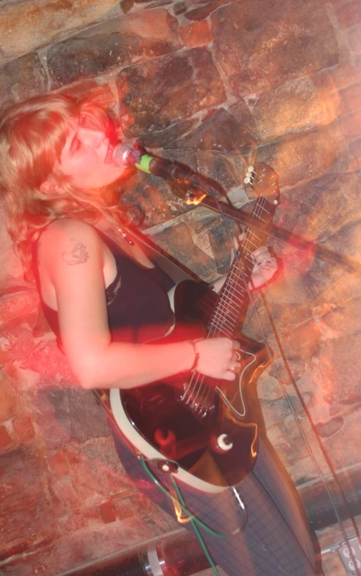 girl in black dress with red sunglasses playing guitar